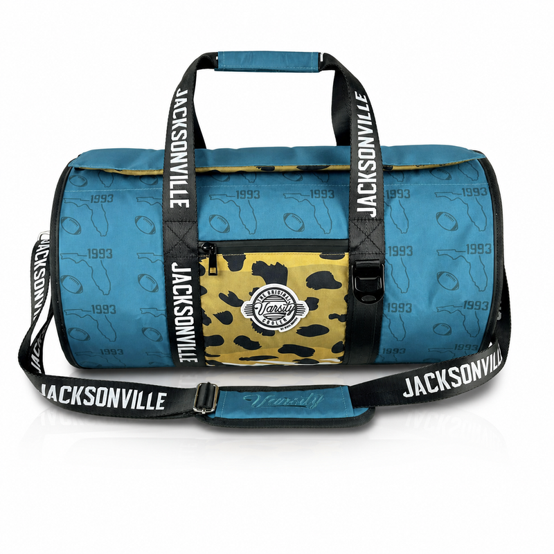 Jacksonville Varsity duffel cooler, front view with teal exterior and black straps